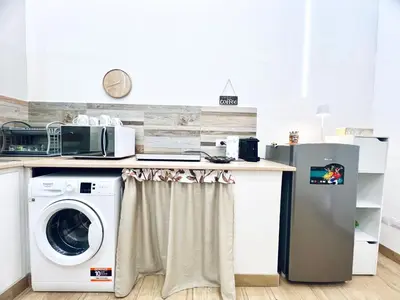 a kitchen with a washer and dryer under a counter at Giglio Home in Palermo