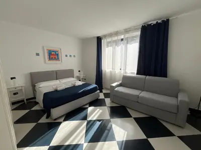 a bedroom with a bed and a couch and a checkered floor at Casa Galati in Palermo
