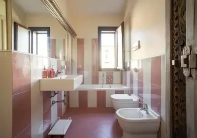 a bathroom with two toilets and a sink and a tub at Seaside Villa in Carini