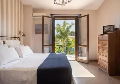 a bedroom with a bed and a dresser and a window at Seaside Villa in Carini