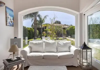 a living room with a white couch and a large window at Seaside Villa in Carini