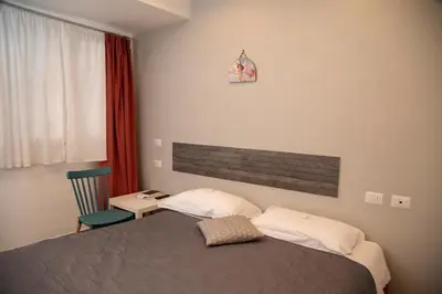 a bedroom with a bed and a chair and a window at Leon D'Oro in Corleone