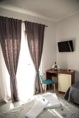 a bedroom with a window with a chair and a desk at Leon D'Oro in Corleone