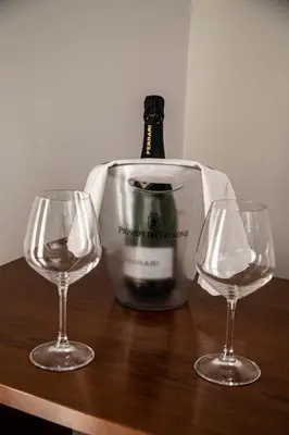 a bottle of wine and two wine glasses on a table at Leon D'Oro in Corleone