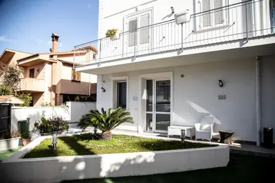 a white house with a garden in front of it at Leon D'Oro in Corleone