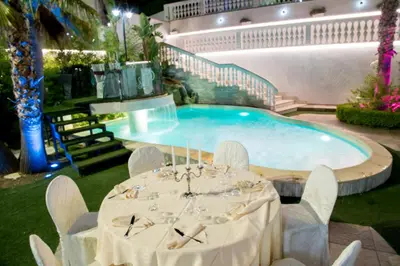 a table with chairs in front of a swimming pool at Leon D'Oro in Corleone