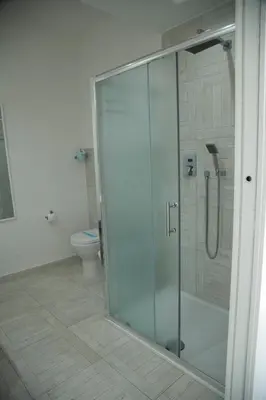 a glass shower in a bathroom with a toilet at Leon D'Oro in Corleone