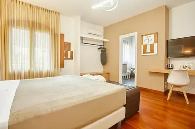 a bedroom with a large bed and a desk at Hotel La Tavernetta in Scopello