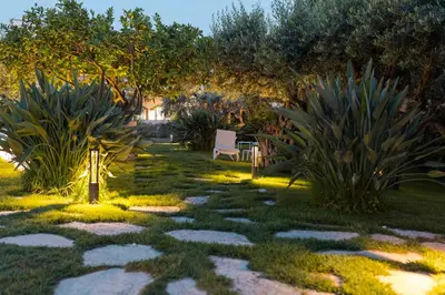 a garden with a light in the grass at Hotel La Tavernetta in Scopello