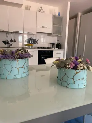 two buckets of flowers sitting on a kitchen counter at Casa Dorotea in Nuova Gibellina