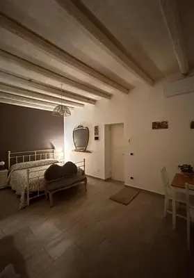 a bedroom with a bed and a table and a chair at Loft Ballarò in Palermo