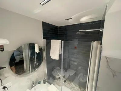 a bathroom with a shower and a sink and a mirror at Belvedere Suite in Termini Imerese