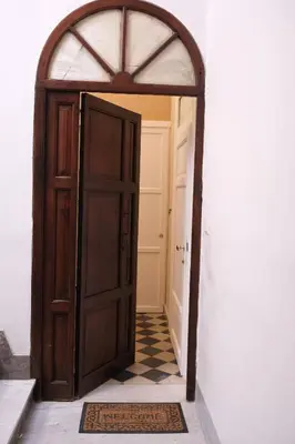 an open door into a hallway with a checkered floor at Belvedere Suite in Termini Imerese