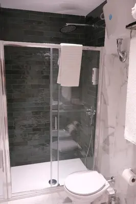 a bathroom with a shower with a toilet and a sink at Belvedere Suite in Termini Imerese