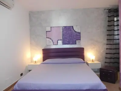 a bedroom with a bed and two lights on two tables at Busalacchi B&B in Mondello