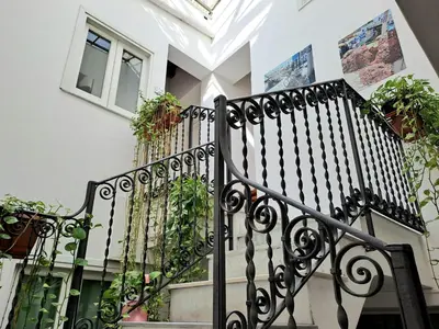a black wrought iron staircase with potted plants at Ai Tintori in Palermo