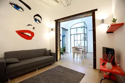 a living room with a couch and a dining room at La Casetta delle Scienze Suite in Palermo