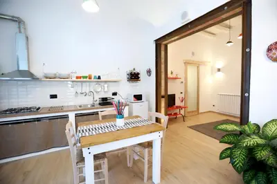a kitchen and dining room with a table and chairs at La Casetta delle Scienze Suite in Palermo