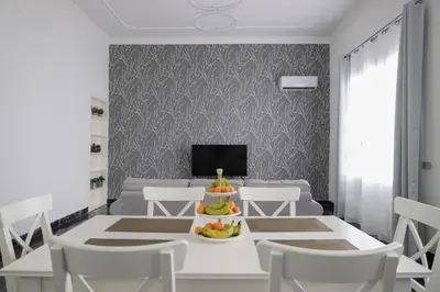 a dining room with a white table and chairs at Casa Costanzo in Capaci