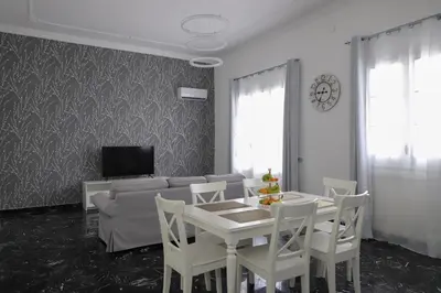 a living room with a couch and a table and chairs at Casa Costanzo in Capaci