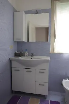 a bathroom with a white sink and a mirror at Casa Costanzo in Capaci