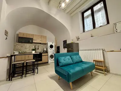 a living room with a blue couch and a kitchen at Cozy apartment near Palermo Cathedral in Palermo