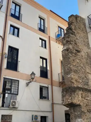 a building in front of a large rock at Cozy apartment near Palermo Cathedral in Palermo