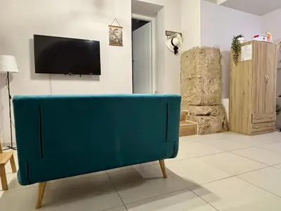 a blue couch in a living room with a tv at Cozy apartment near Palermo Cathedral in Palermo