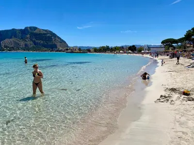 a woman standing in the water on a beach at Cozy apartment near Palermo Cathedral in Palermo