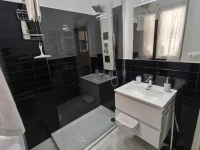 a black tiled bathroom with a sink and a shower at Casa Cristy palermo in Palermo
