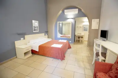a bedroom with a bed and a tv in a room at Le Plejadi in Castellammare del Golfo