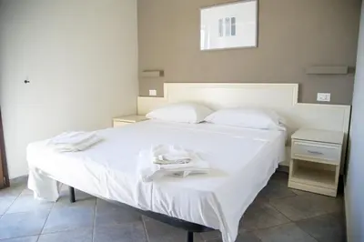 a bed with white sheets and towels on it at Le Plejadi in Castellammare del Golfo