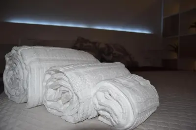 a pile of white towels laying on a bed at Domus Ponente in Terrasini