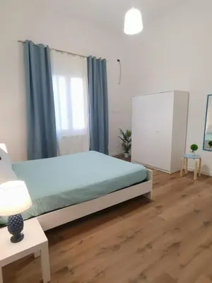 a bedroom with a bed with blue sheets and a window at Mondello sicily apartament in Mondello
