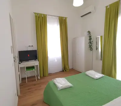 a bedroom with two green beds and a television at Mondello sicily apartament in Mondello