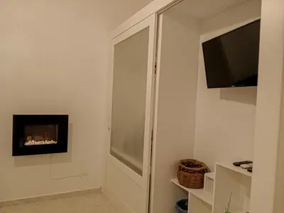 a bathroom with a cabinet with a fireplace and a television at Casa Sedie Volanti in Palermo