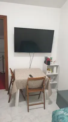 a table with two chairs and a television on a wall at Casa Vacanze San Martino in Corleone