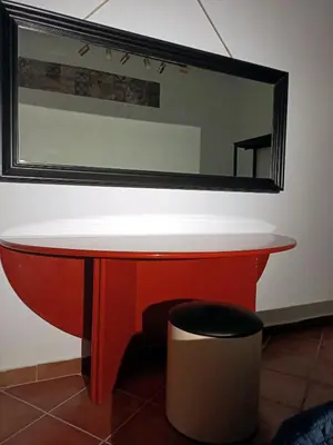 a red table with a mirror on the wall at Sofia Holiday Home in Palermo