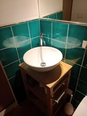 a bathroom with a sink and a green tiled wall at Sofia Holiday Home in Palermo