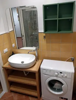 a bathroom with a sink and a washing machine at Sofia Holiday Home in Palermo