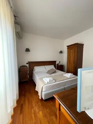 a bedroom with a large bed and a wooden desk at Hotel La Piazzetta in Castellammare del Golfo
