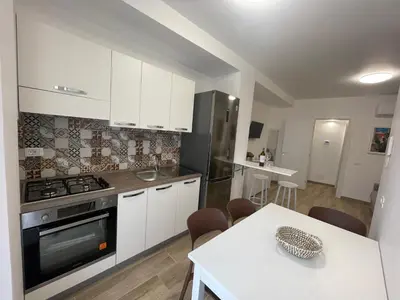 a kitchen with white cabinets and a stove and a table at Casa Himera Palermo in Palermo