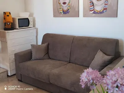a brown couch in a living room with a tv at La vecchia Badessa a due passi dal mare in Macari