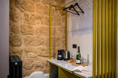 a room with a stone wall and a counter with wine bottles at Art e Dimora - Boutique Room. in Castellammare del Golfo