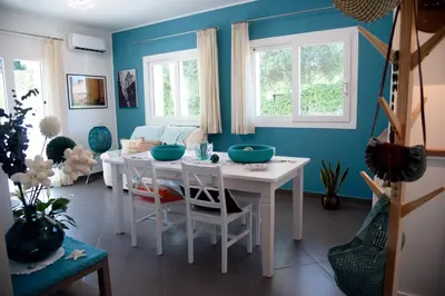 a dining room with a white table and blue walls at Villa Deluxe con Idromassaggio in Palermo