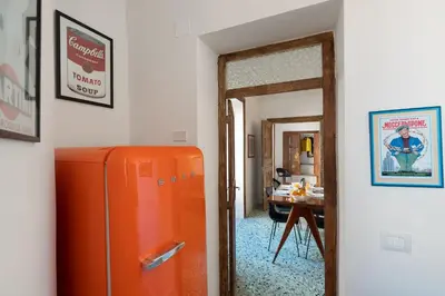 an orange refrigerator in a room with a table at 124 Maqueda Apartments in Palermo