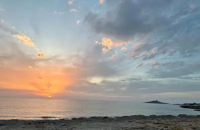 a sunset over the ocean with a cloudy sky at Villa Jari in Carini