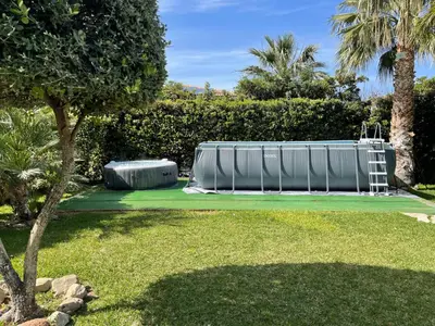 a swimming pool in a yard with a tree at Villa Jari in Carini
