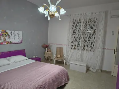 a bedroom with a bed and a chandelier at Casa Vacanze Ciccinè in Capaci