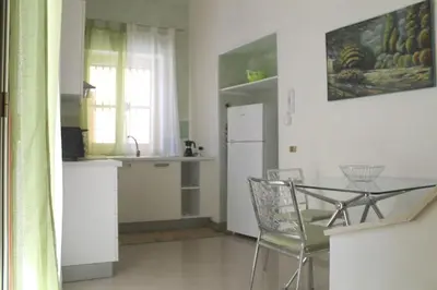 a kitchen with a table and chairs and a refrigerator at Casaulente in Alcamo
